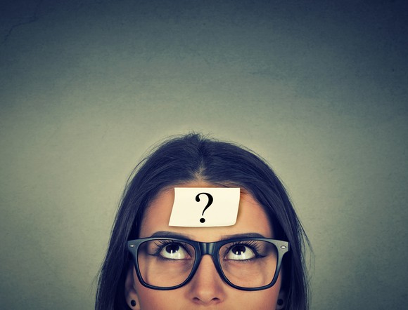 Woman with Post-it not on her head with a question mark on it.