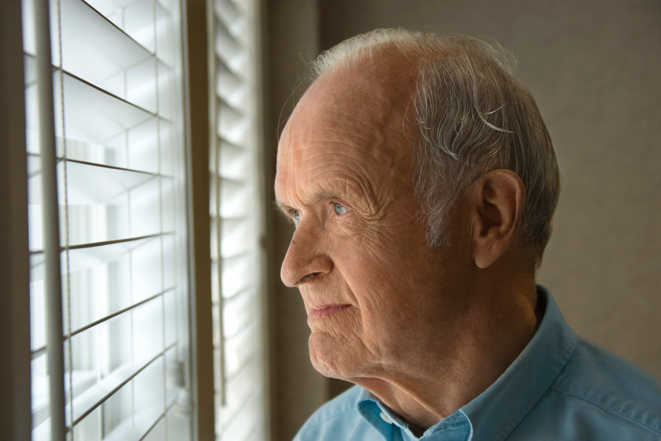 Older man looking out a window