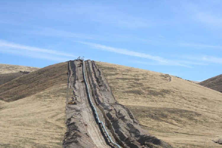 Hill with an excavation for a pipeline going up the side.