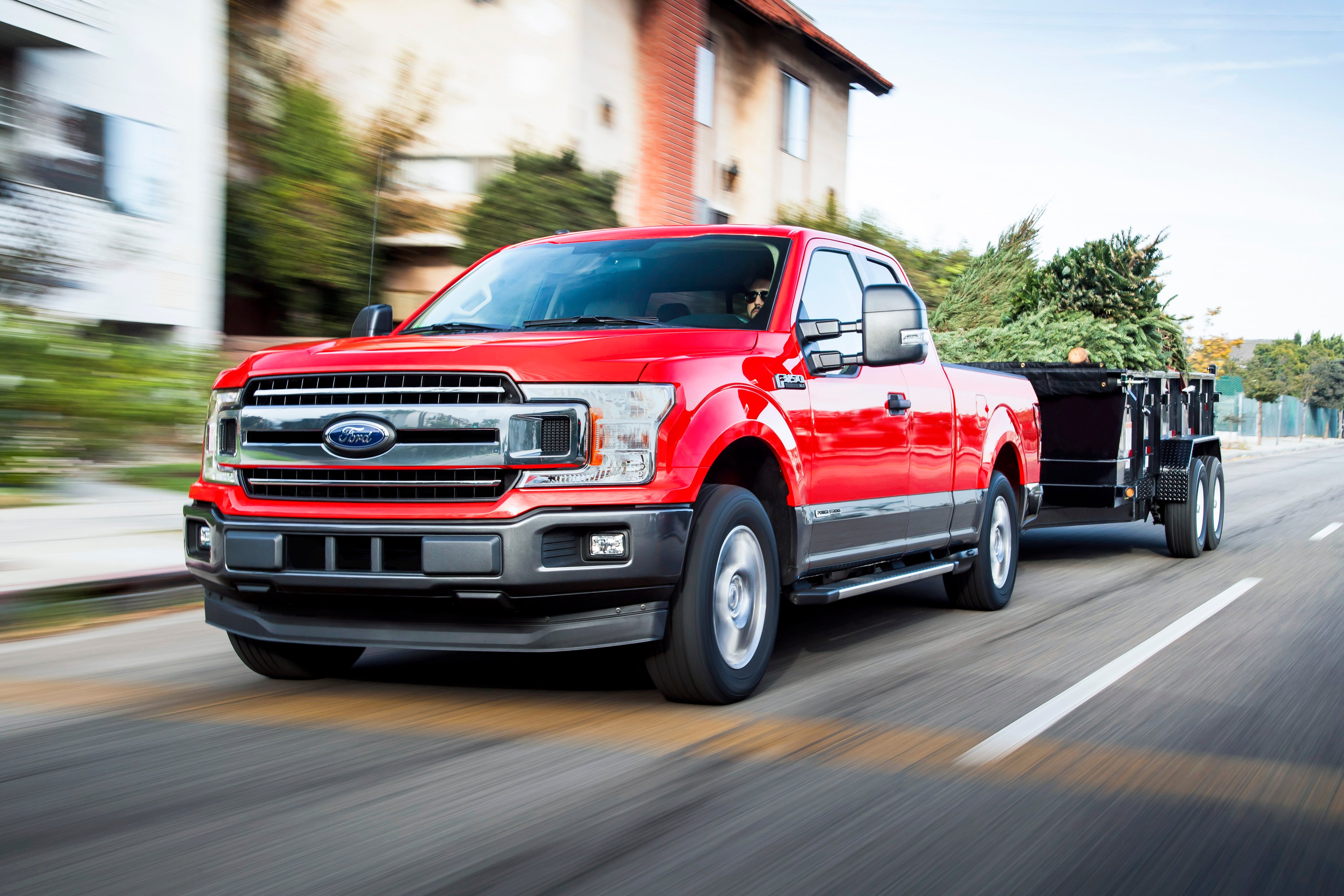 A red Ford F-150 diesel-powered pickup truck is shown pulling a trailer. 