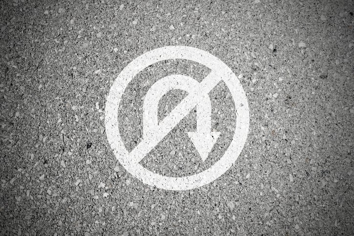 A no u-turn sign drawn on pavement.