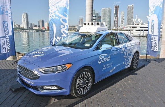 A blue Ford Fusion with driverless vehicle technology mounted on the roof.