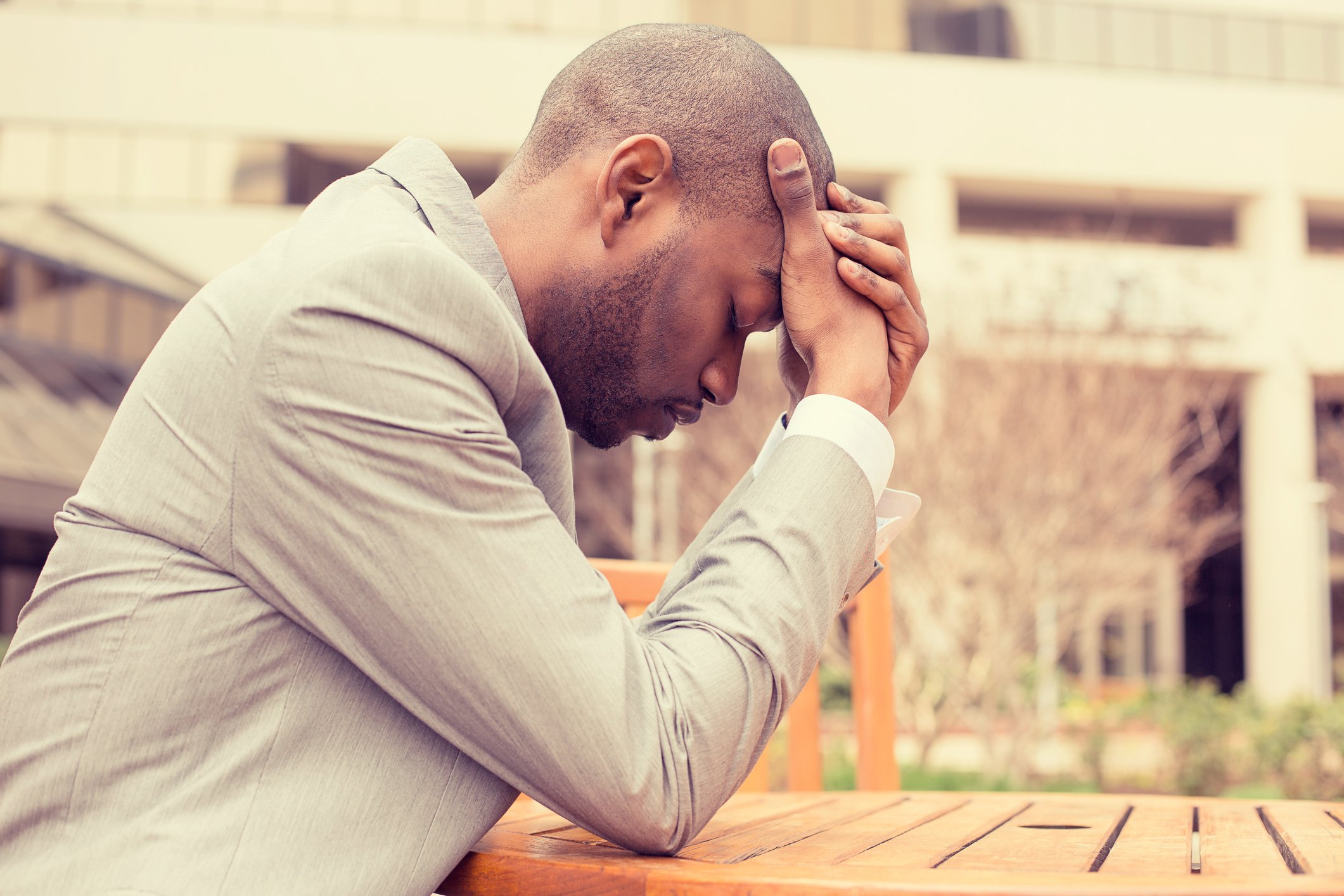Man in dress shirt holding his head as if upset