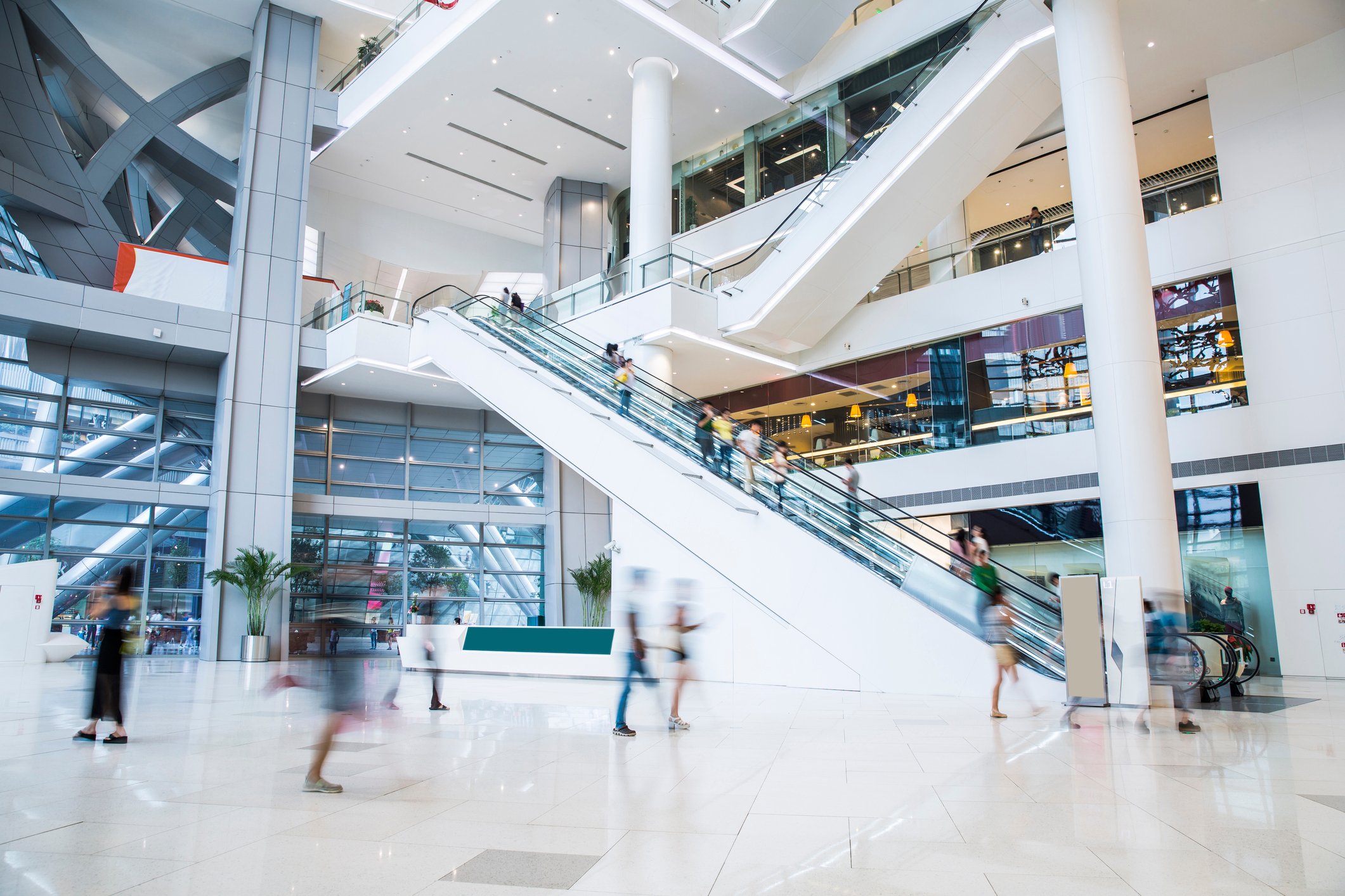 The interior of a mall with shoppers appearing blurry.