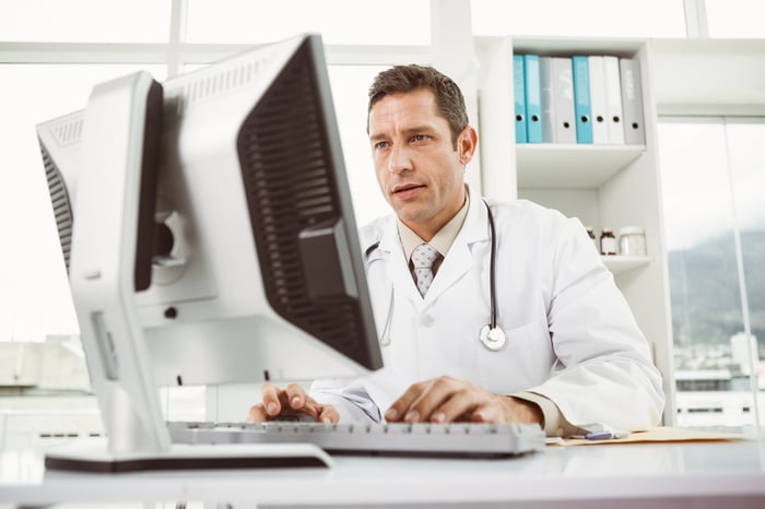 Male doctor working at a computer