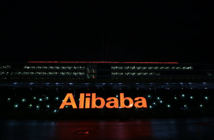 A sign reading "Alibaba" is lit up in orange in front of the company's offices.