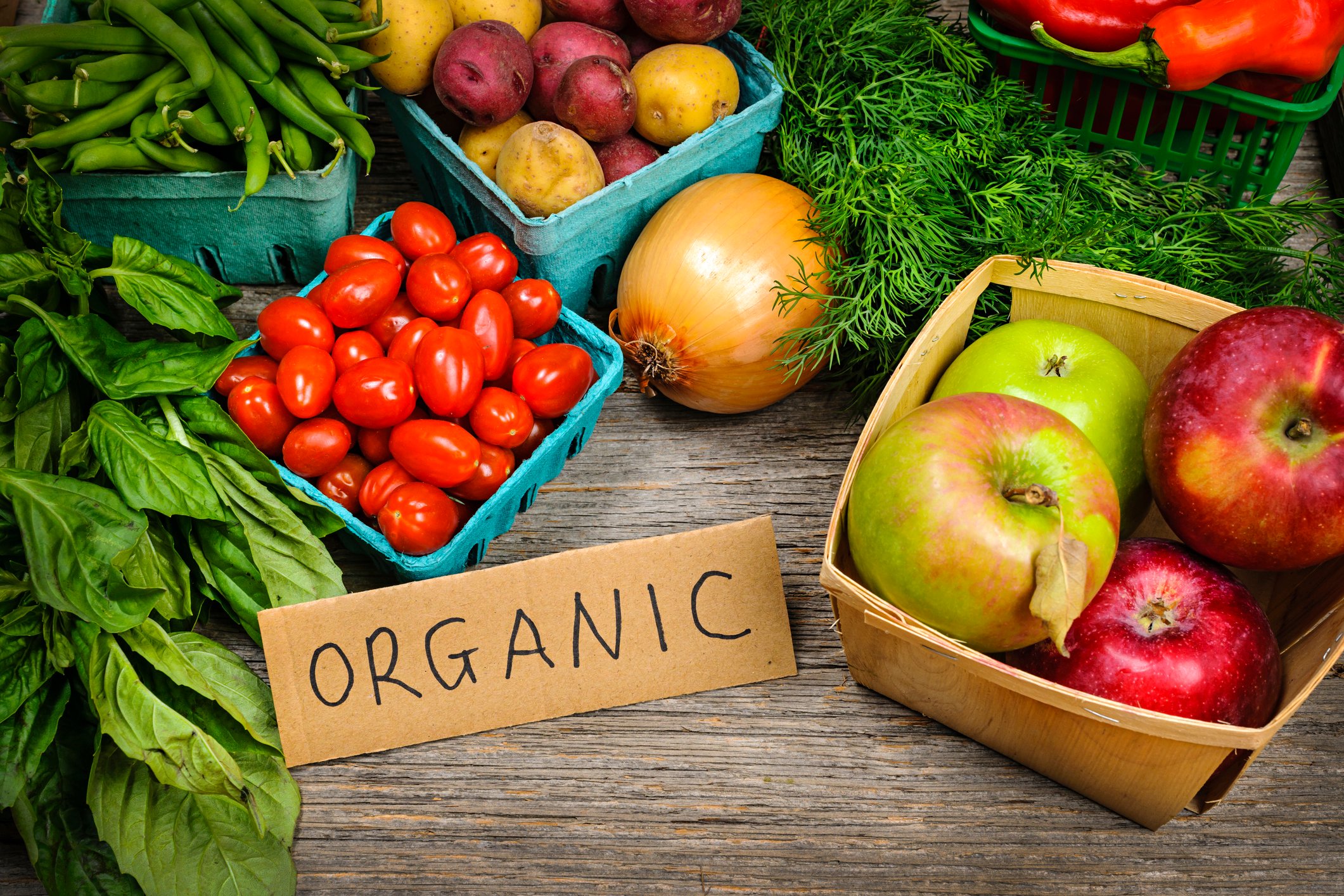 Assorted fruit and vegetable on a table with a label that says "organic."