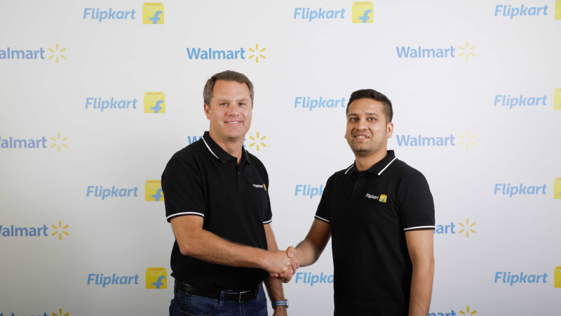 Walmart CEO Doug McMillon shakes hands with Flipkart co-founder Binny Bansal. 