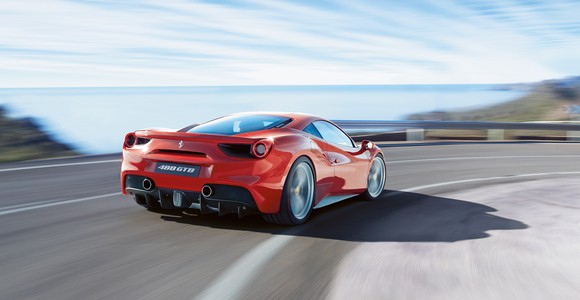 A red Ferrari 488 GTB, a two-seat, mid-engined sports car powered by a V8 engine, is shown at speed on a twisty mountain road. 
