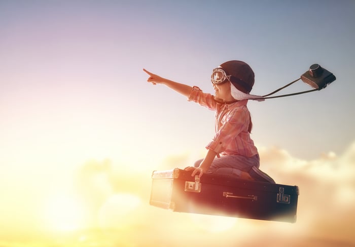 A child rides a rocket into the sky with arm outstretched pointing toward space.