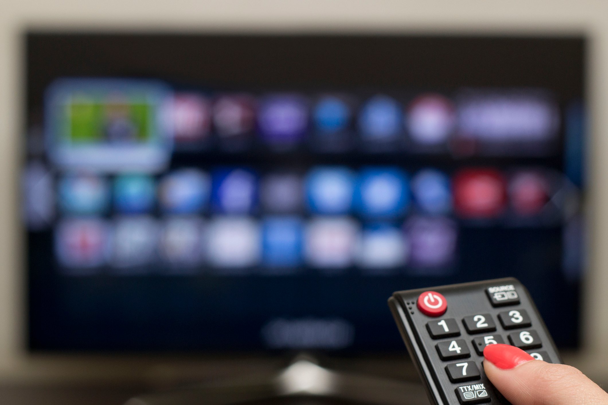 A woman uses a smart TV.