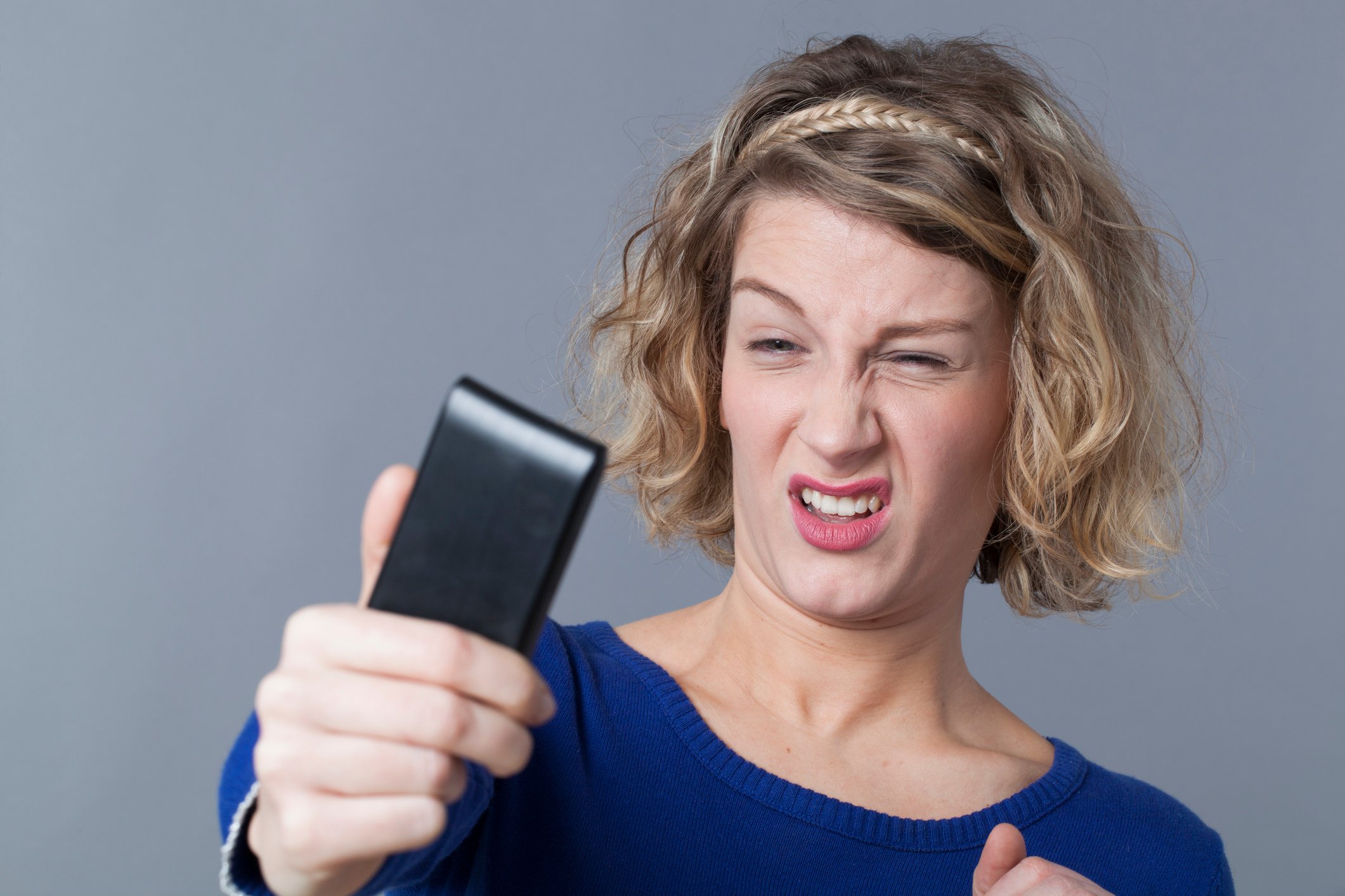 Woman frowning taking selfie