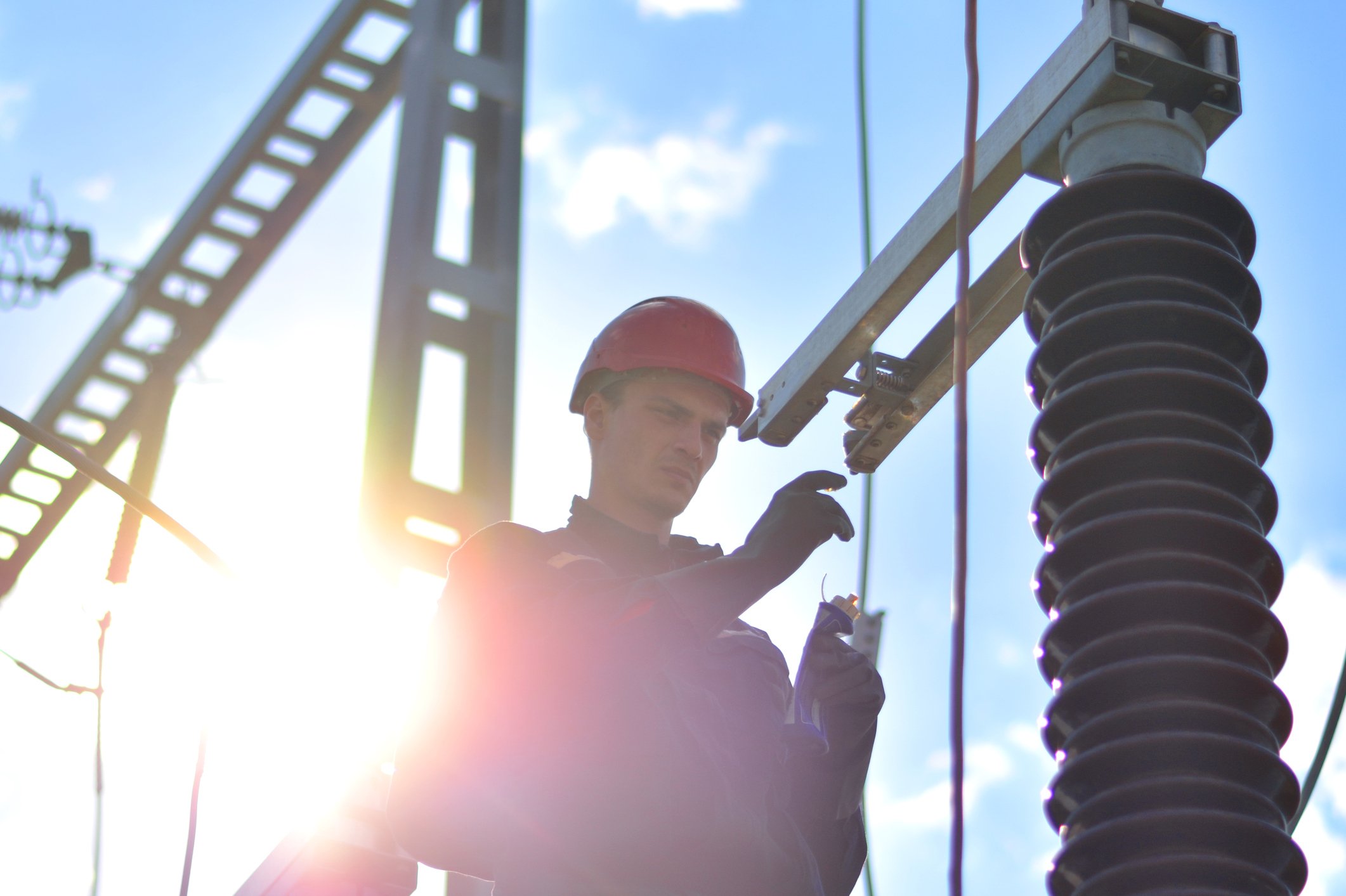 Man wearing a hard hat working on a power substation.