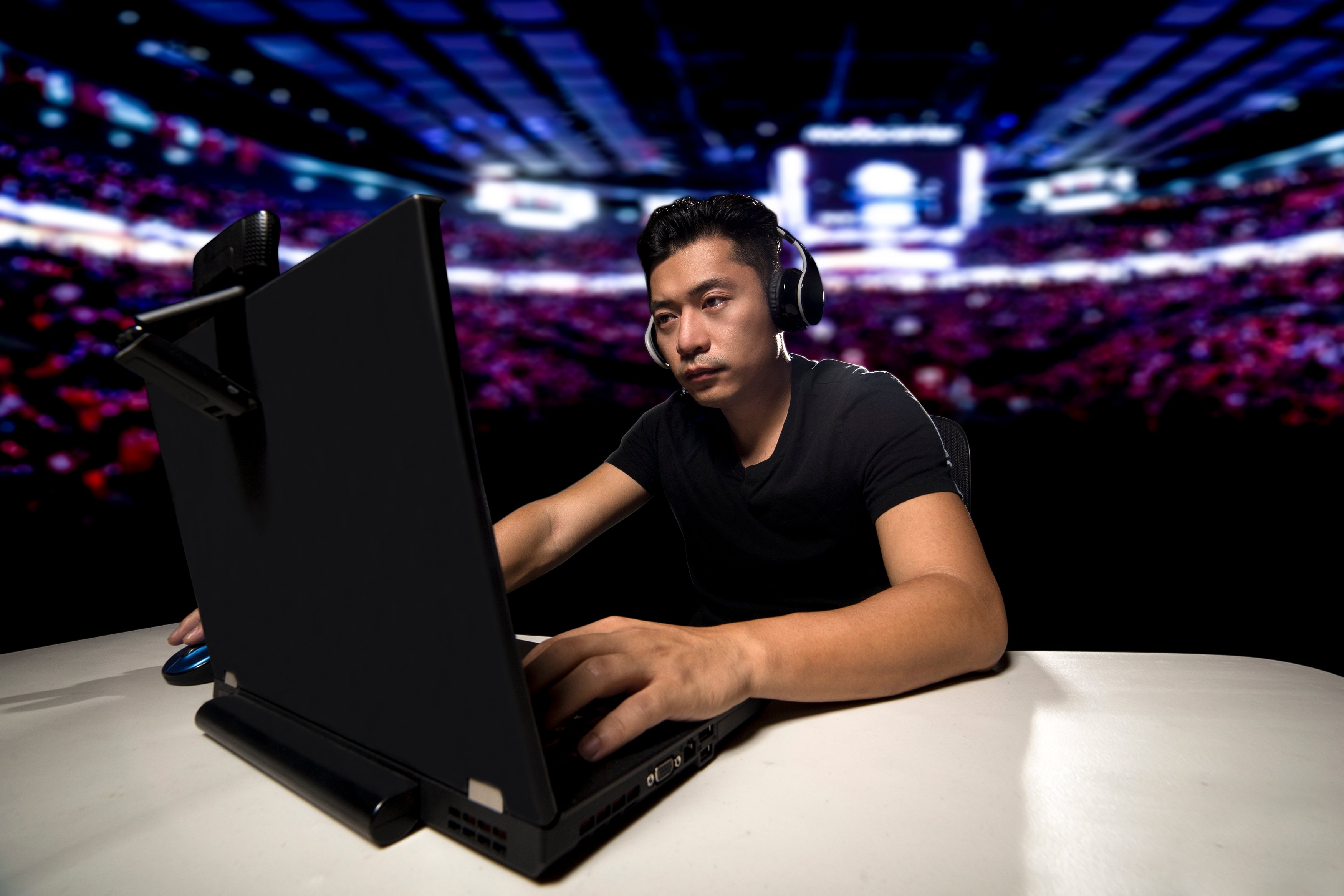 A man plays a video game in an e-sports stadium.