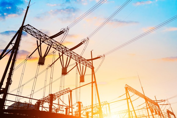 Electric transmission lines with sun in the background.