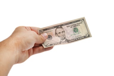 Hand holding $5 bill