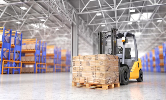 Forklift with pallet of boxed goods in a warehouse.