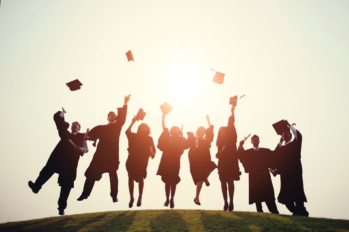 Graduates throw their hats in the air.