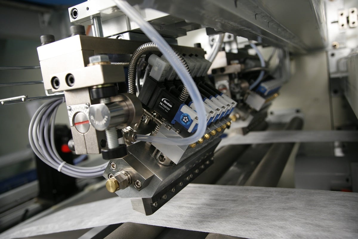 Nordson adhesive dispensing system with tubes and nozzles