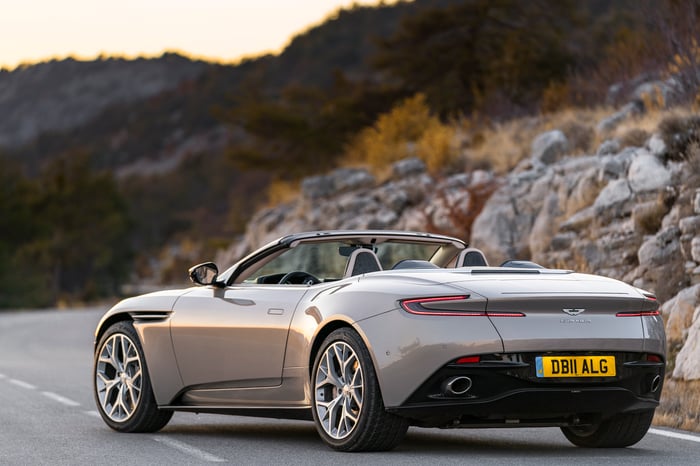 A silver Aston Martin DB11 Volante, a sleek luxury-sports convertible, shown from a rear three-quarter view.