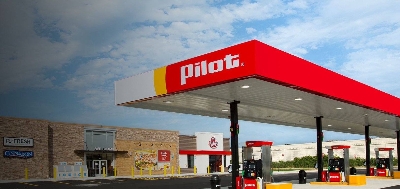 Gas station awning with Pilot logo on it, in front of storefront.