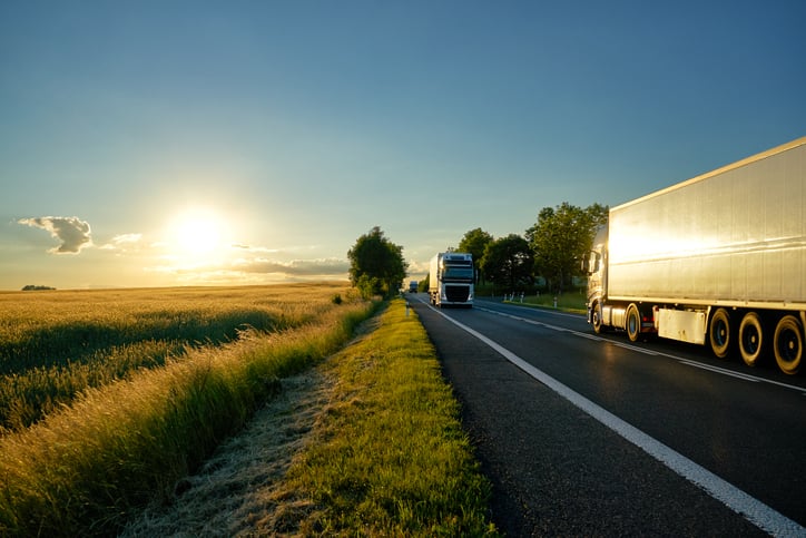 Two semi trucks passing on a country road.
