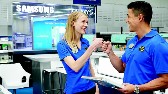 Two Best Buy employees fist bump.