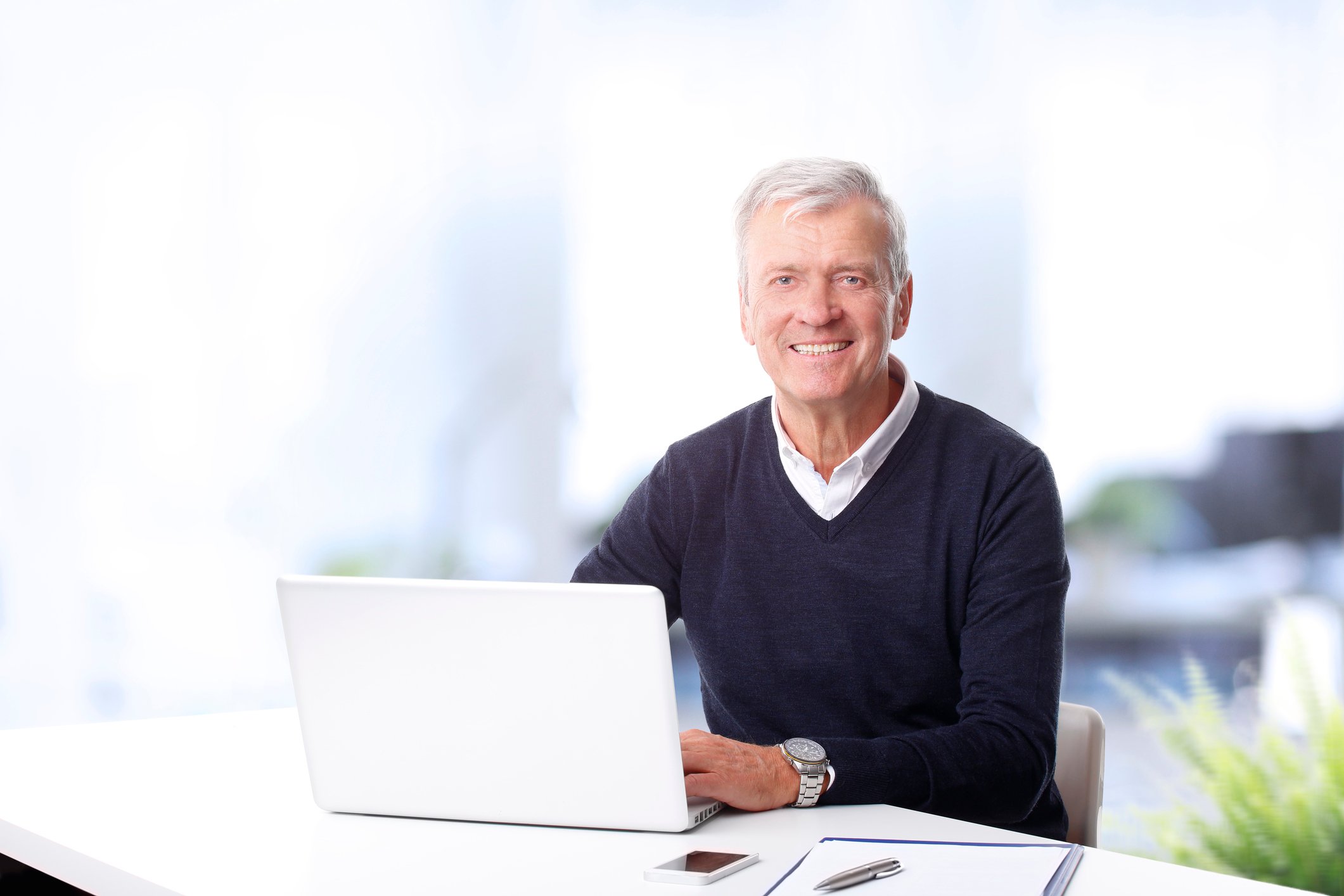 Older man at a laptop, smiling