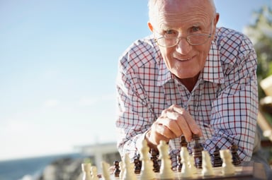 Senior Man Playing Chess on Beach Getty
