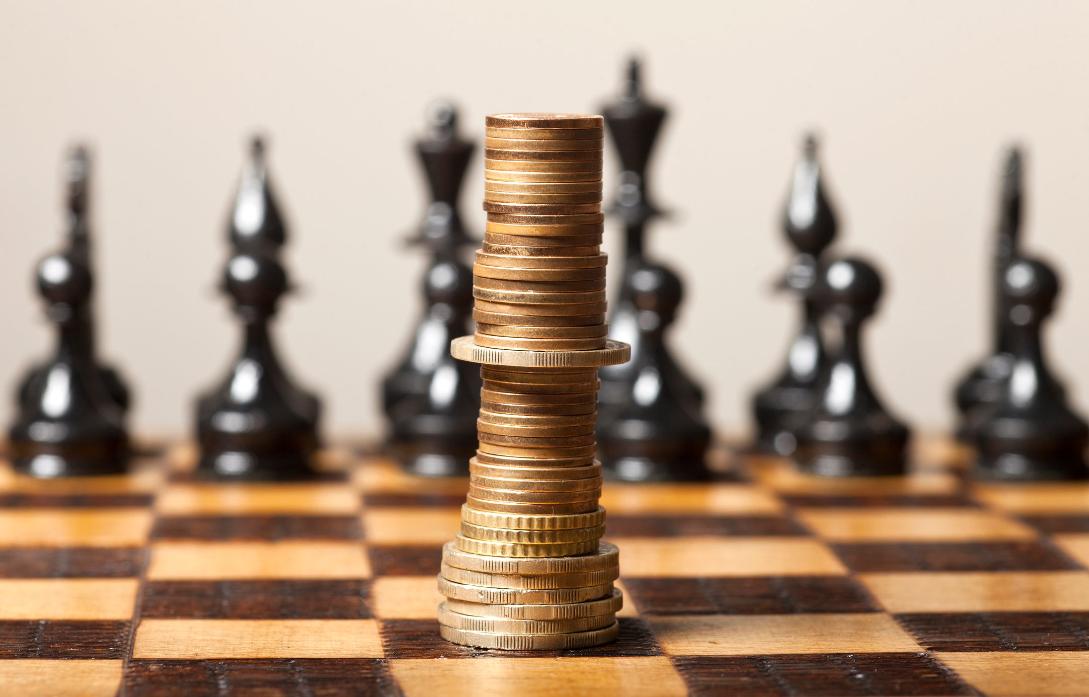 Coins stacked like a king on a chess board.