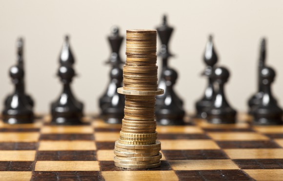 Coins stacked like a king on a chess board.