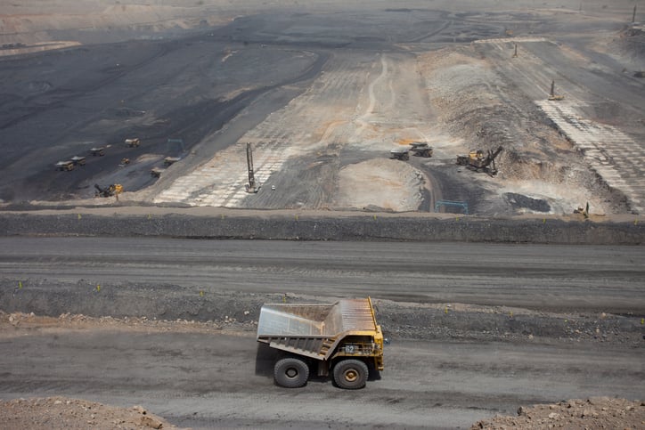 A giant earth hauler driving down a road at a Chinese coal mine.