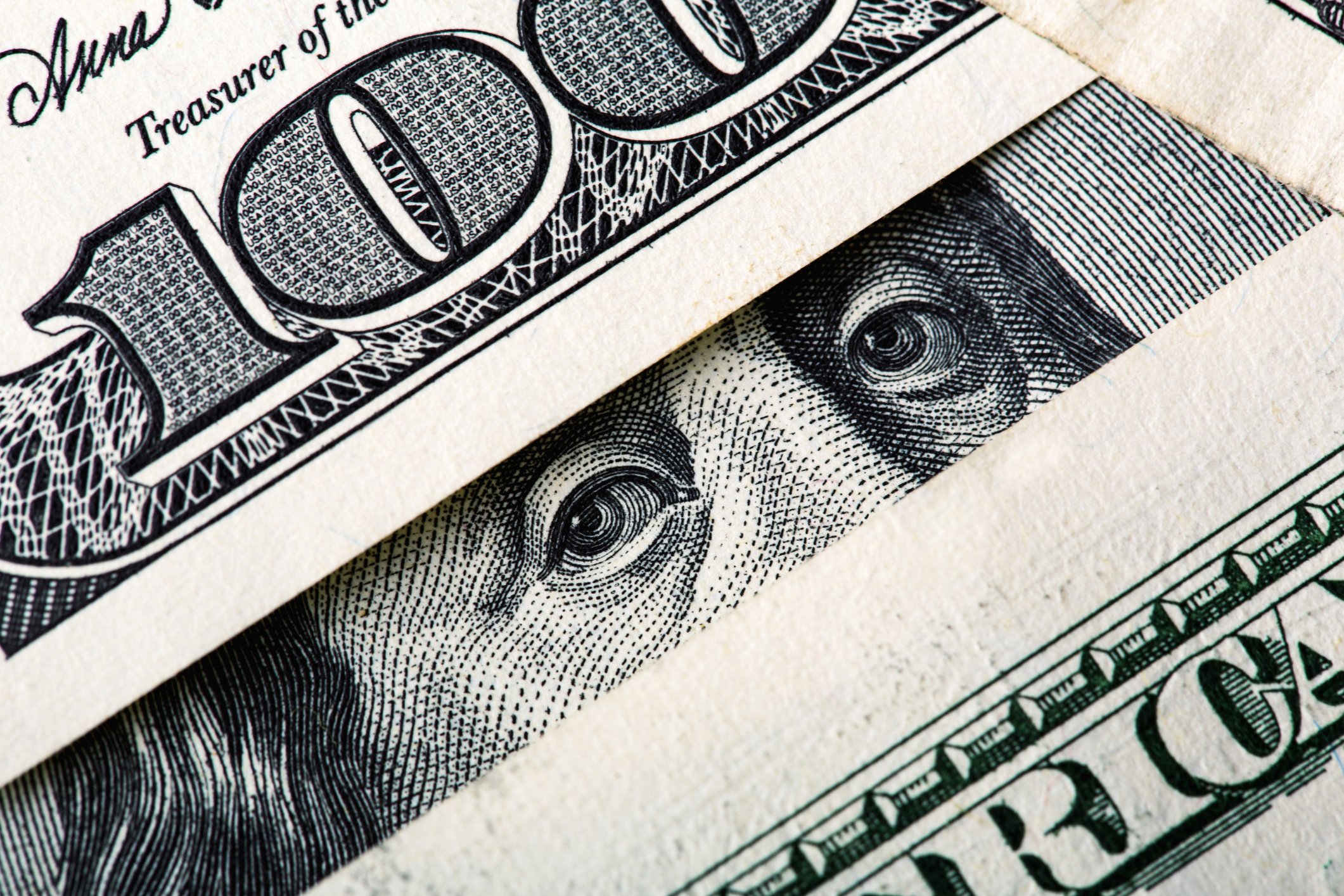 $100 bills framing Benjamin Franklin's eyes