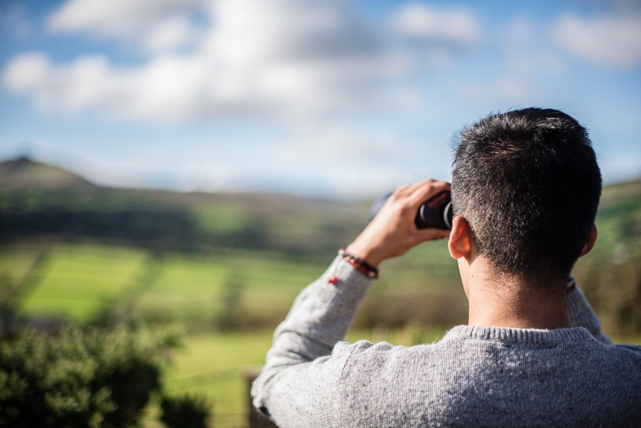 Man with binoculars looking off into the distance