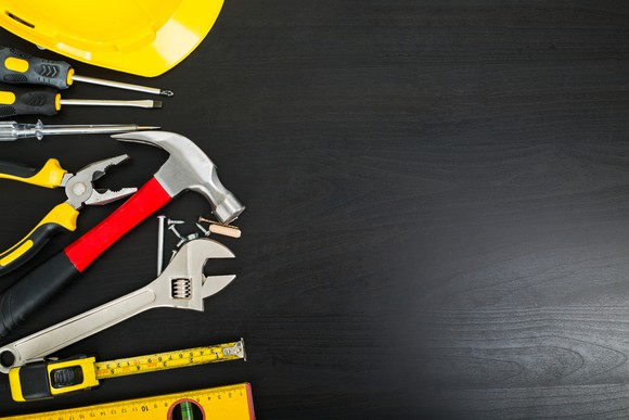 A variety of tools laid out on a black surface.