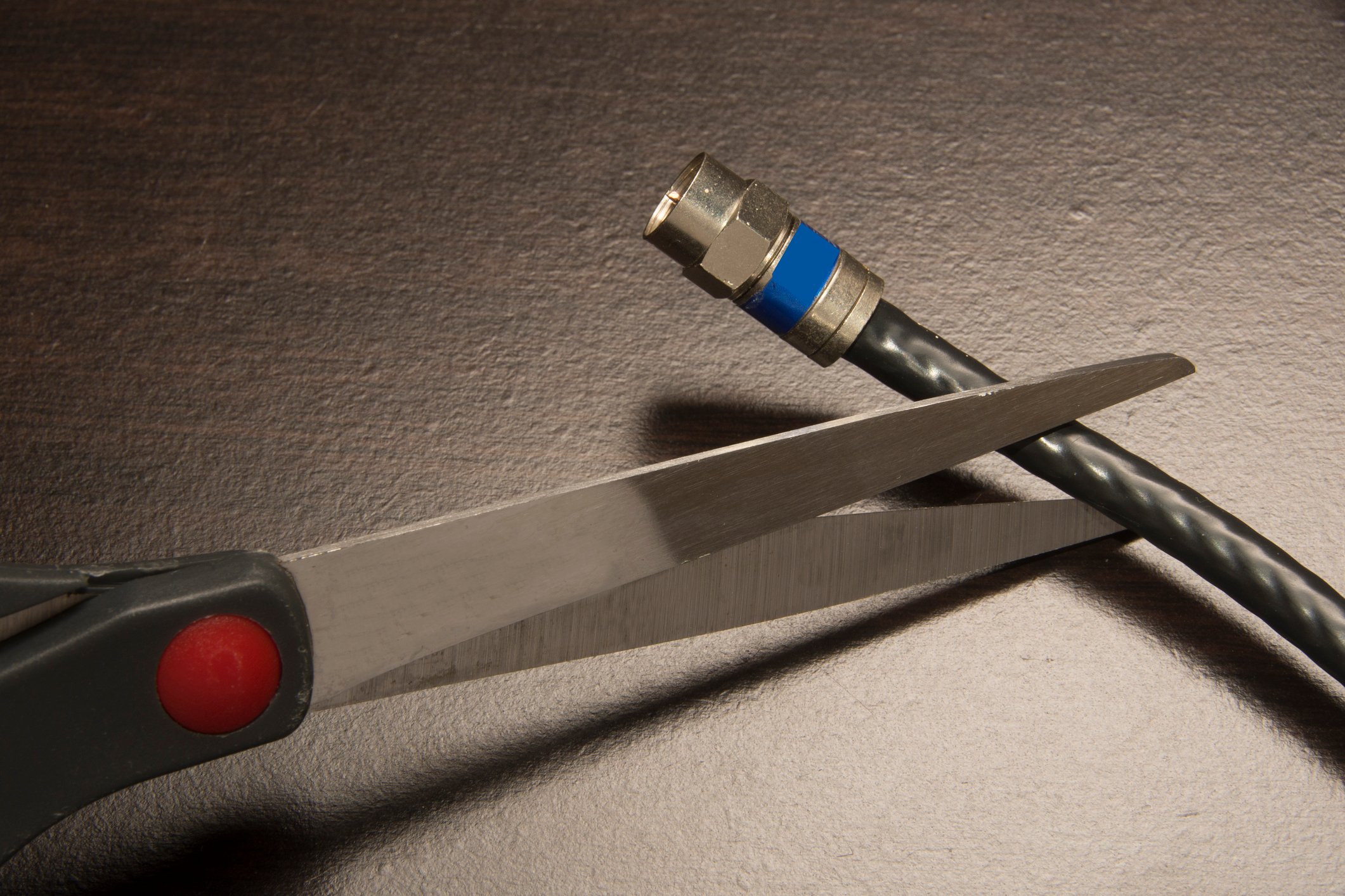 Scissors cutting a cable cord.