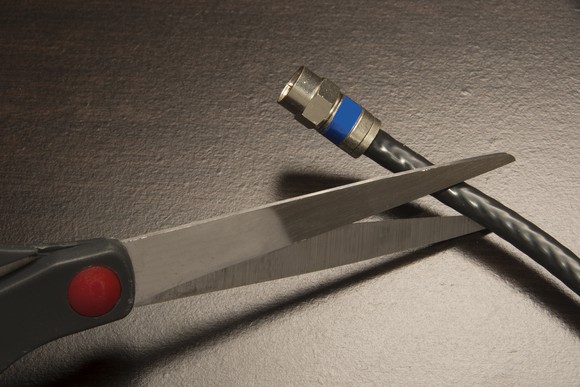 Scissors cutting a cable cord.