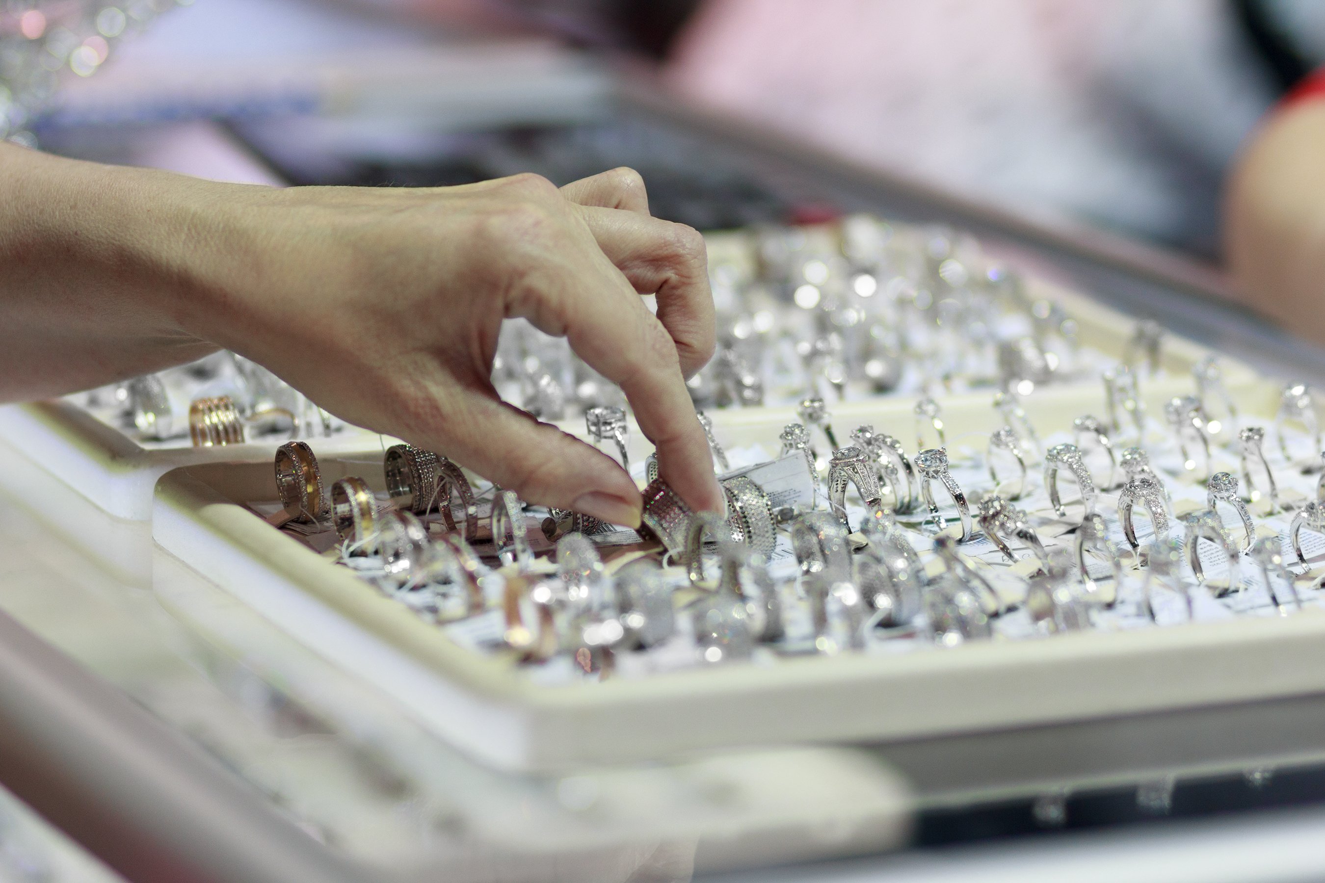 A woman's hand touching a selection of diamond rings