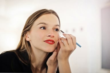 Woman Applying Eye Make-Up In Front of Mirror