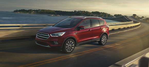 A red 2018 Ford Escape, a compact crossover SUV, on a waterfront road.