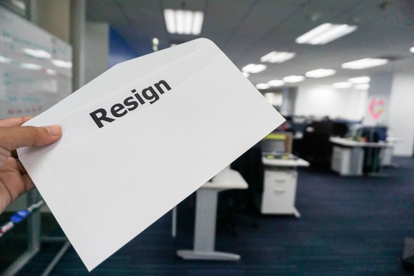Person holding envelope with the word resign