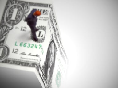 Man standing on edge of $1 bill