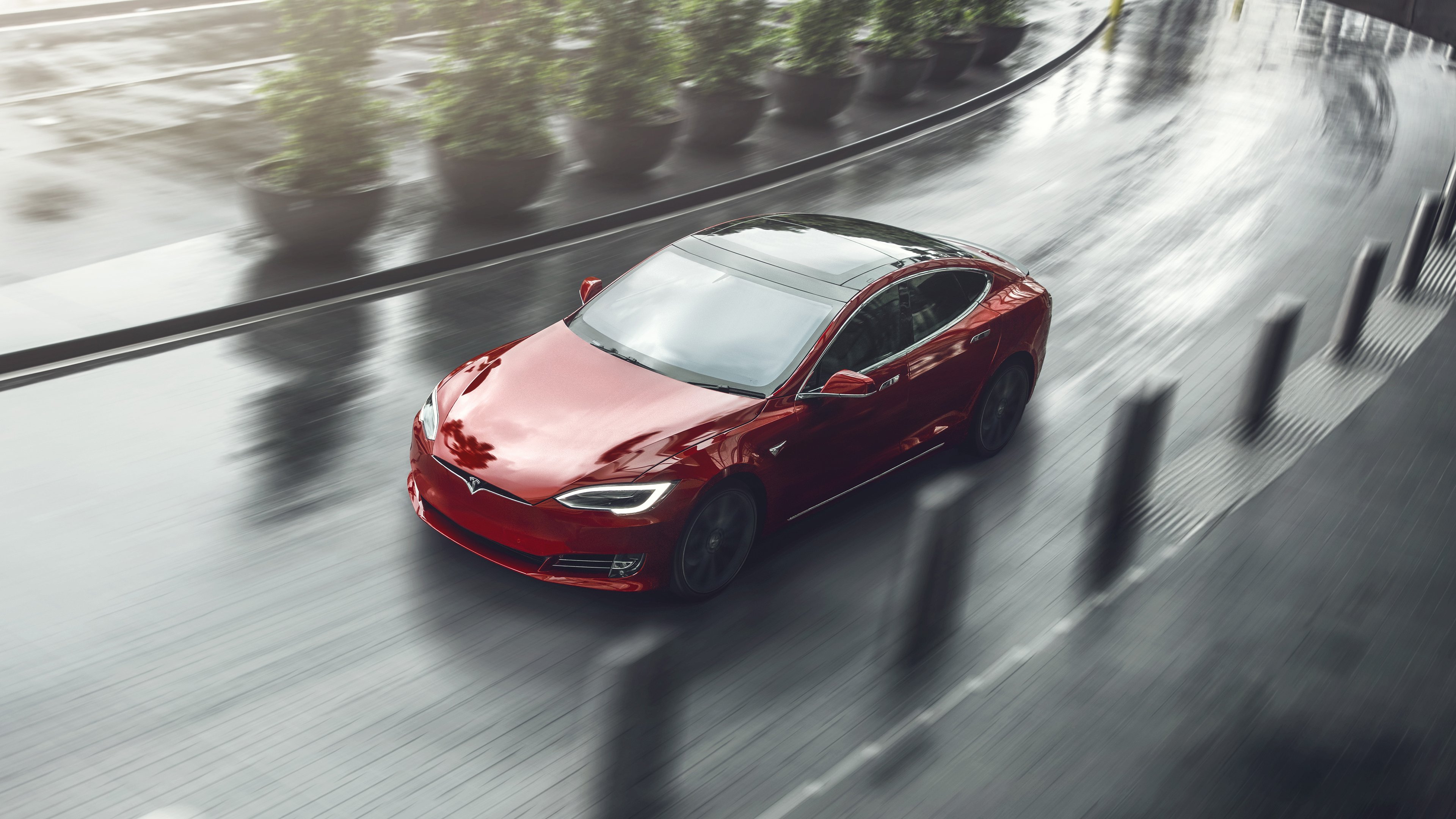 Red Model S driving on a curved road
