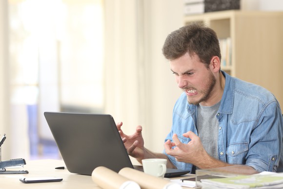 Man at laptop looking angry 