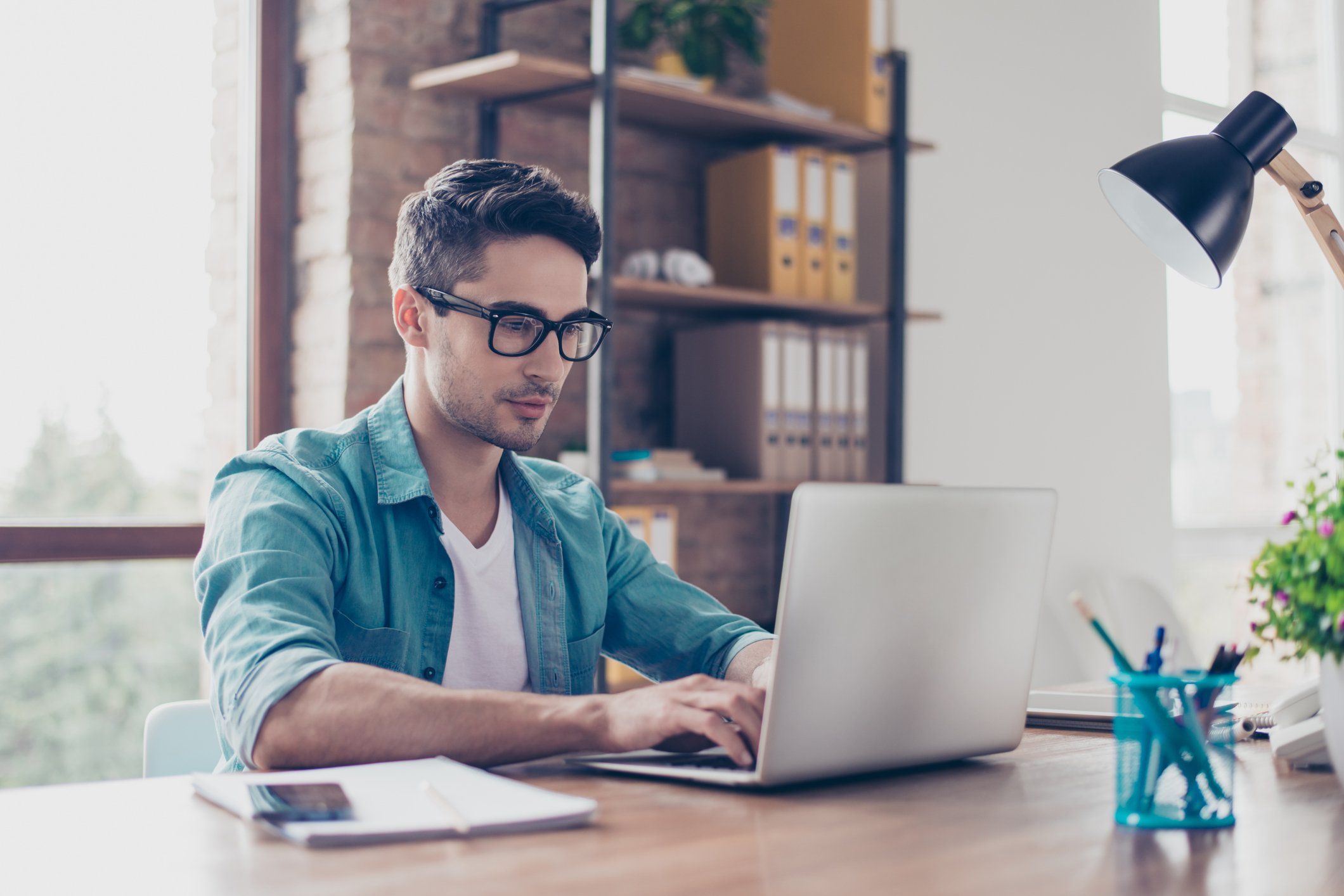 Young adult male typing on a laptop