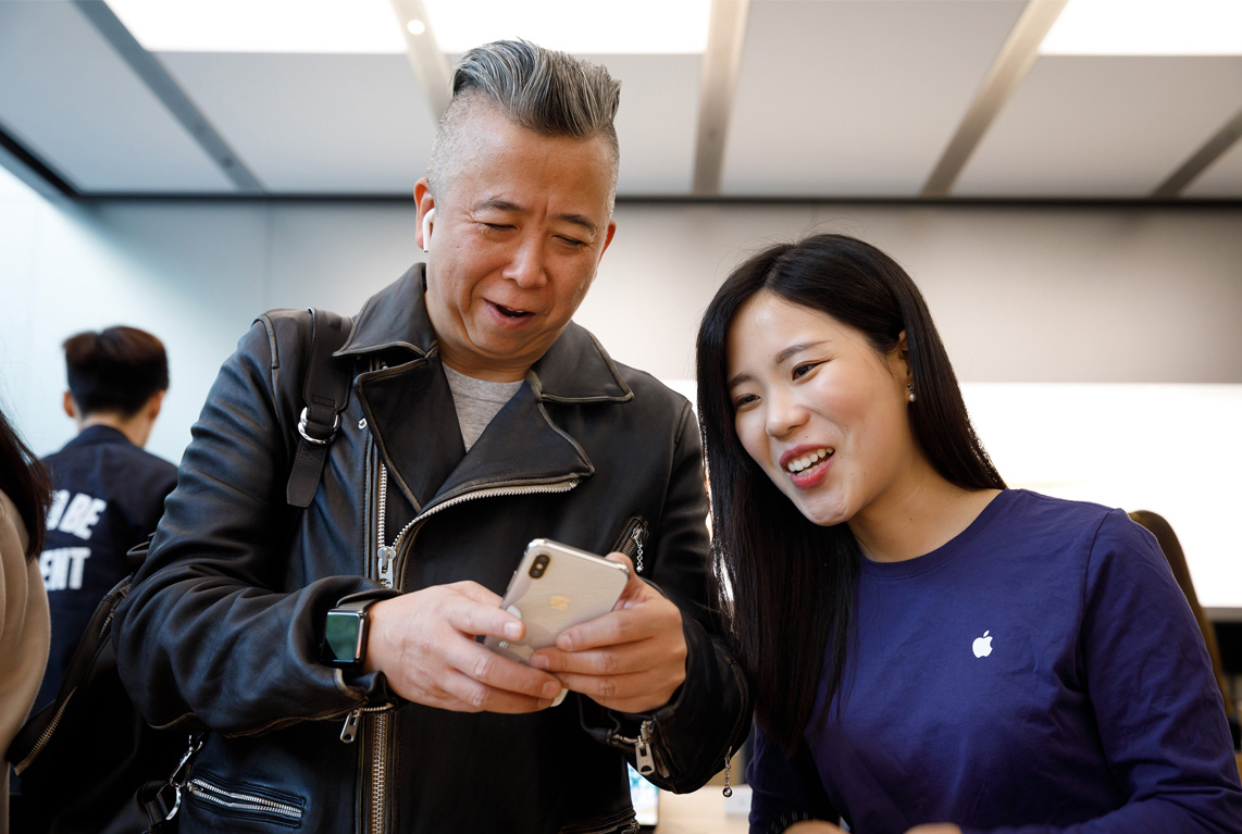 A customer holding a new iPhone X at an Apple Store in China