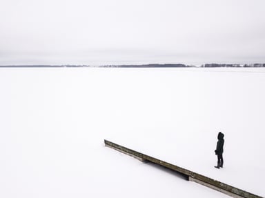 Woman in Winter Parka Standing at Frozen Lake