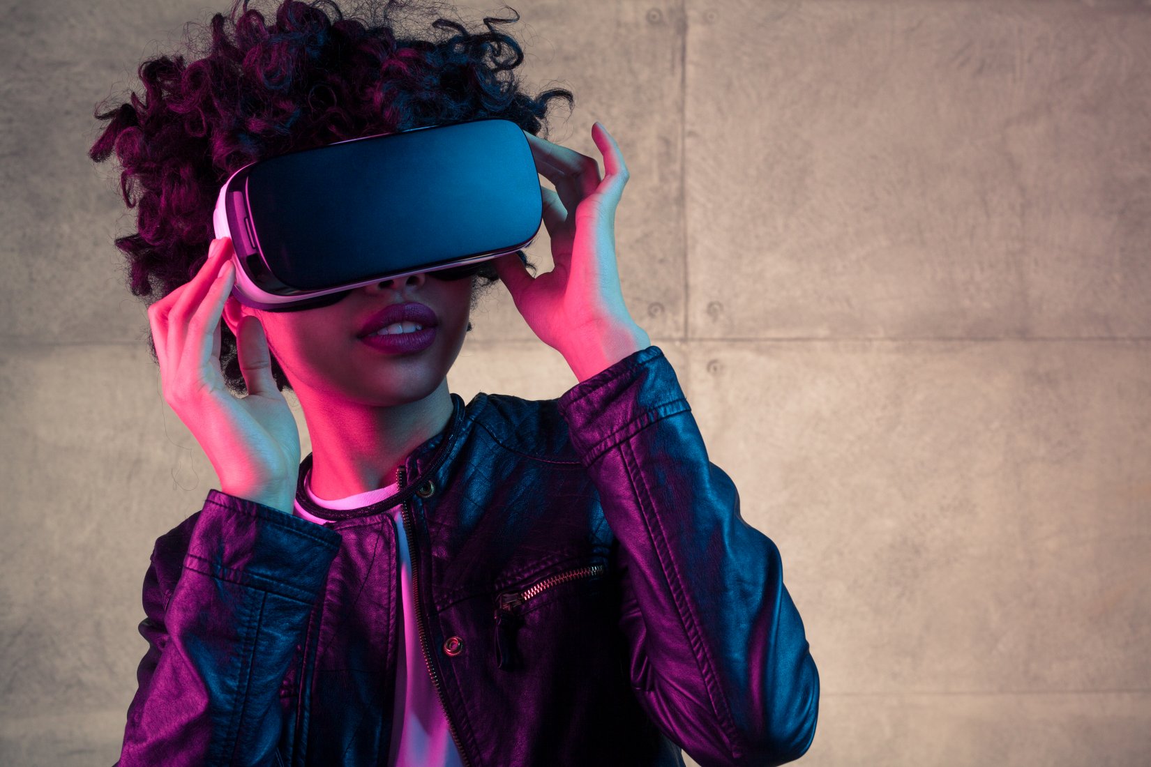 A young woman uses a VR headset.