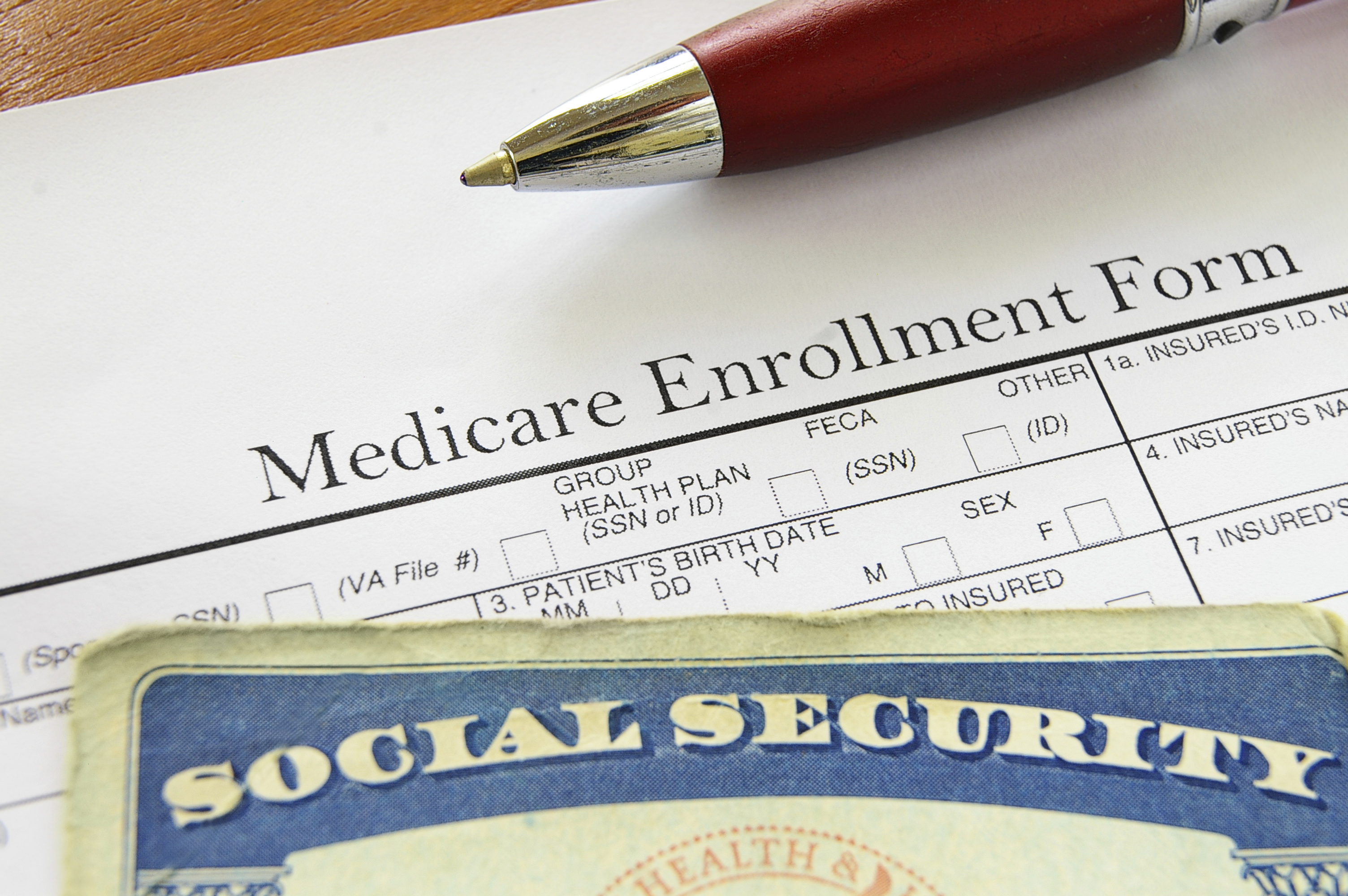Medicare enrollment form with Social Security card on top.