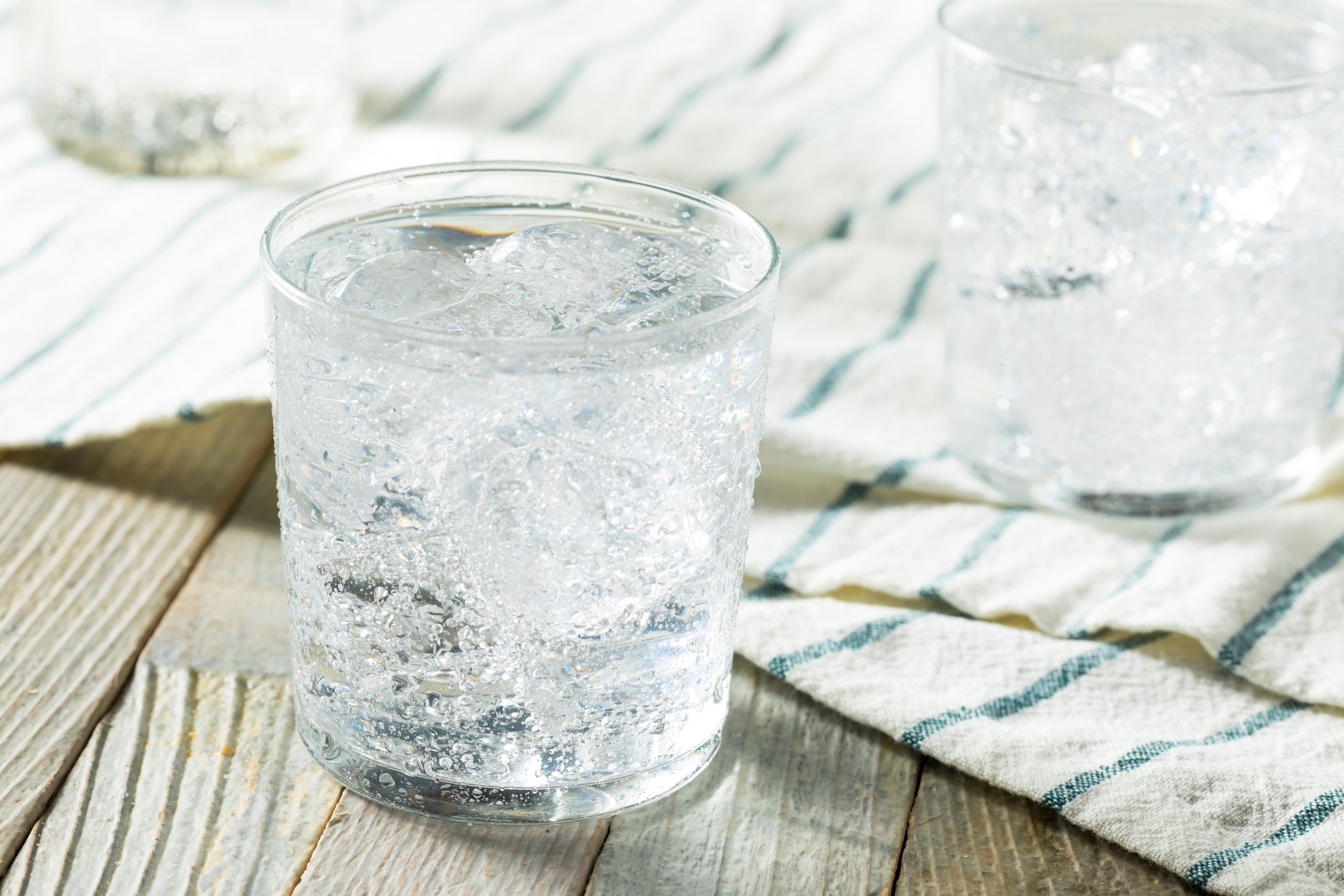 Sparkling water in a glass on a wood table. 